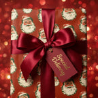 Vintage Santa Christmas wrapping paper with a luxury burgundy bow and gift tag by Wrapped Studios.