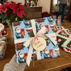 Retro blue Santa Christmas gift wrap by Wrapped Studios on a present with a cream bow and gift tag.