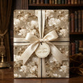 Elegant vintage floral wrapping paper with a cream satin bow and gift tag by Wrapped Studios.