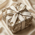 Vintage floral wrapping paper on a gift box with cream bow on champagne silk, by Wrapped Studios.