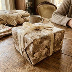 Vintage floral wrapping paper with cream velvet ribbon on a luxury gift box by Wrapped Studios.
