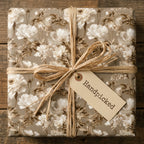 Luxury vintage floral wrapping paper with cream botanical pattern and a raffia bow by Wrapped Studios.