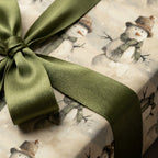 Vintage snowman Christmas wrapping paper with a sage green satin ribbon from Wrapped Studios.