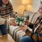Christmas gift exchange featuring snowman wrapping paper and green ribbon by Wrapped Studios.