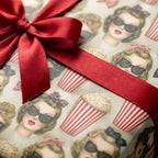Retro vintage wrapping paper with 1950s movie girls, popcorn, and a red satin bow by Wrapped Studios.