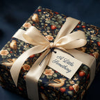 Elegant gift wrapped in floral wrapping paper featuring birds and strawberries, with a cream ribbon and a gift tag.