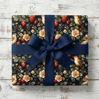 Elegant floral wrapping paper with strawberry and bird pattern, tied with a navy ribbon.