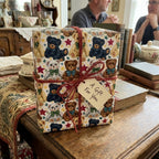 Vintage teddy bear wrapping paper on a gift tied with red twine and tag, by Wrapped Studios.