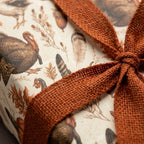 Rustic Thanksgiving wrapping paper with vintage turkey print and orange burlap ribbon by Wrapped Studios.