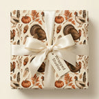 Thanksgiving wrapping paper with turkeys and pumpkins and a cream satin bow from Wrapped Studios.