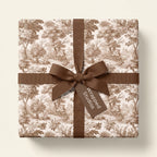 Vintage toile wrapping paper in brown and cream, tied with a grosgrain ribbon bow by Wrapped Studios.