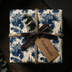 Blue vintage toile wrapping paper with castle print and velvet bow. Luxury gift wrap by Wrapped Studios.