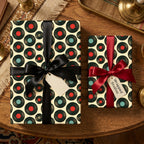 Retro vinyl record wrapping paper with black and red ribbons on gift boxes by Wrapped Studios.
