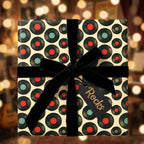 Retro vinyl record music wrapping paper with a black velvet bow and 'Rocks' gift tag by Wrapped Studios.