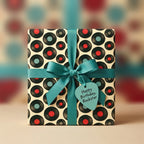 Retro vinyl record birthday wrapping paper with teal ribbon and rockstar tag by Wrapped Studios.