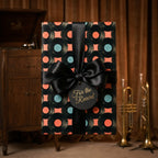 Retro vinyl record wrapping paper with a black satin bow by Wrapped Studios.