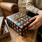 Retro vinyl record wrapping paper on a gift with gold bow. Music themed gift wrap by Wrapped Studios.