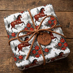 Rustic horse Christmas wrapping paper with leather bow on wood background, by Wrapped Studios.