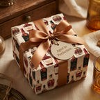 Vintage whiskey wrapping paper on a gift box with a bronze ribbon and "Aged to Perfection" tag by Wrapped Studios.