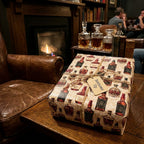 Whiskey wrapping paper by Wrapped Studios on a gift box with twine in a cozy fireplace lounge.