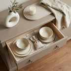 Beige floral wrapping paper used as a drawer liner for ceramic dishes. By Wrapped Studios.