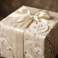 Elegant vintage floral wrapping paper in cream with a satin bow by Wrapped Studios.