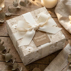 Vintage floral wrapping paper in beige and cream with a ribbon bow on a gift box by Wrapped Studios.
