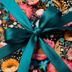 Floral birthday wrapping paper with teal ribbon.