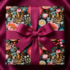 Floral wrapping paper on a gift box with a wine-colored ribbon bow from Wrapped Studios.