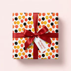 Playful balloon birthday wrapping paper with a red ribbon and gift tag by Wrapped Studios.