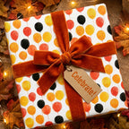 Fall balloon birthday wrapping paper with rust velvet bow and Celebrate tag, by Wrapped Studios.