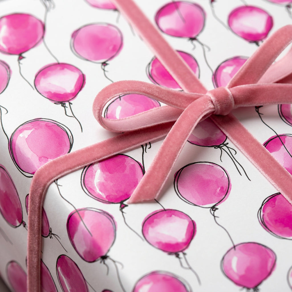 Gift wrapped in pink balloon birthday wrapping paper with velvet ribbon.