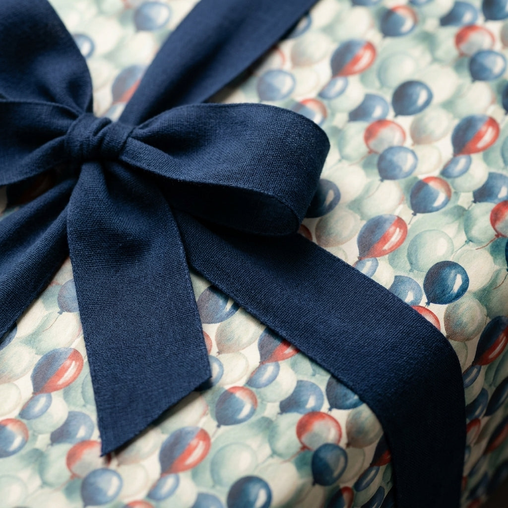 Vintage balloon birthday wrapping paper with a luxury navy blue ribbon bow by Wrapped Studios.