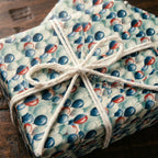 Playful balloon birthday wrapping paper tied with a white twine bow by Wrapped Studios.