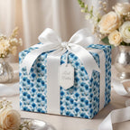Luxury blue floral wrapping paper with a white satin bow and gift tag by Wrapped Studios.