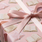 Book wrapping paper in blush pink with a matching satin bow, by Wrapped Studios.