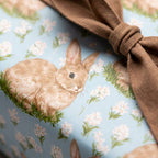 Vintage bunny wrapping paper in light blue with white flowers and a brown bow from Wrapped Studios.