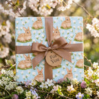 Easter bunny wrapping paper on a gift box with a brown satin bow, by Wrapped Studios.