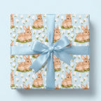 Bunny wrapping paper with a blue satin bow for Easter or baby showers, by Wrapped Studios.