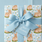 Easter bunny wrapping paper in light blue with matching bow and gift tag by Wrapped Studios.