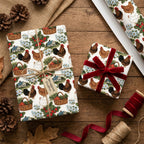 Rustic chicken wrapping paper by Wrapped Studios on gifts with a red velvet ribbon on a wooden table.