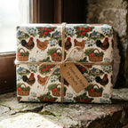 Rustic farmhouse wrapping paper with chickens by Wrapped Studios, tied with twine on a stone ledge.