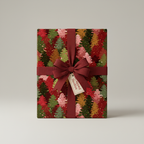Elegant Christmas gift wrapped in red and green tree print wrapping paper with a ribbon bow.