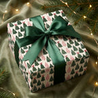 Christmas wrapping paper featuring a pink and green pine tree pattern and green satin bow by Wrapped Studios.