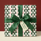 Elegant Christmas tree wrapping paper in green and pink with a satin ribbon bow by Wrapped Studios.