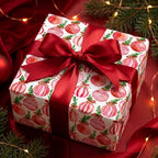 Luxury Christmas wrapping paper with watercolor ornaments and red satin bow by Wrapped Studios.