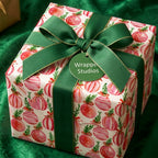 Watercolor pink ornament Christmas gift wrap with a luxury green ribbon by Wrapped Studios.