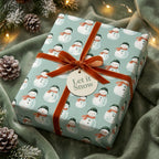 Snowman Christmas gift wrap with rust velvet ribbon on a cozy holiday blanket by Wrapped Studios.