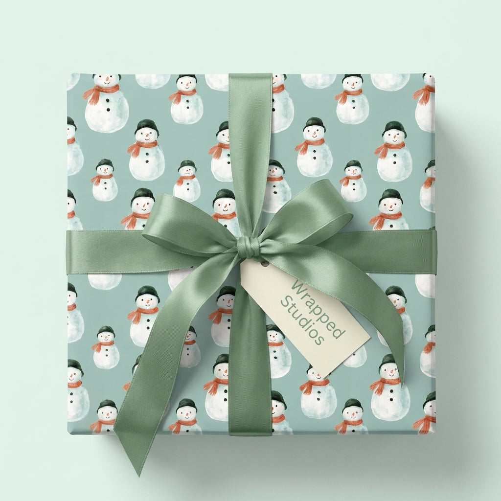 Watercolor snowman Christmas gift wrap with sage green satin ribbon by Wrapped Studios.