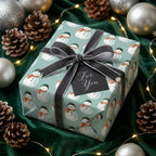 Snowman Christmas wrapping paper with a grey velvet bow on a holiday gift box, by Wrapped Studios.